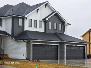 a large white house with a garage at Executive Luxury Suite Unit B in Regina