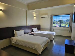 a hotel room with two beds and a window at Hotel Sitiawan in Sitiawan +11 photos