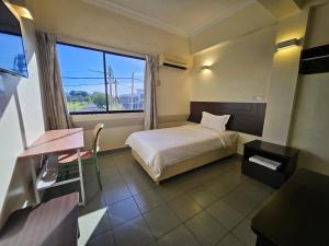 a hotel room with a bed and a window at Hotel Sitiawan in Sitiawan