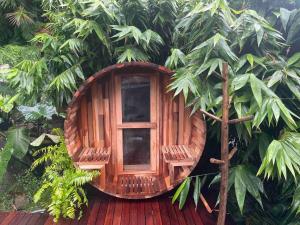 a wooden cabin with a window in a tree at Mackerel Beach Wellness Lodge in Great Mackerel Beach
