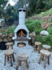 a stone oven with stools in front of it at Mackerel Beach Wellness Lodge in Great Mackerel Beach +38 photos