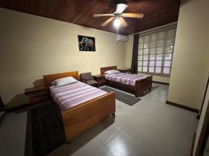 a bedroom with two beds and a ceiling fan at Full house, 2 Bedroom & kitchen in Bocas Town