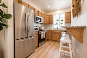 a kitchen with wooden cabinets and a stainless steel refrigerator at Coastal Chateau Cottages in Ocean City +57 photos
