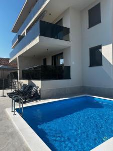 a house with a swimming pool next to a building at Palm Blues in Vodice