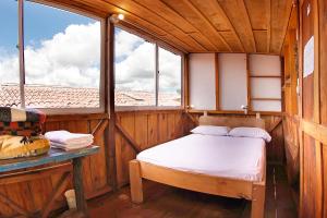 a small room with a bed and a window at Hostal La Casa De Lili in Salento