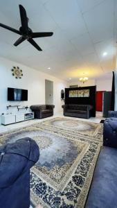 a living room with a couch and a ceiling fan at PD Best Homestay in Port Dickson