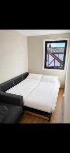 a bedroom with a bed and a couch and a window at Rekkehus i Sandnes in Stavanger