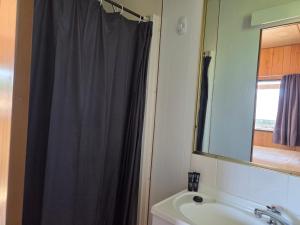 a bathroom with a shower curtain and a sink at Cooma Holiday Park in Cooma +37 photos