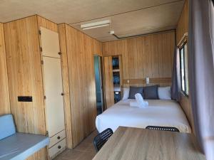a small room with a bed and a table at Cooma Holiday Park in Cooma