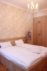 ein Schlafzimmer mit einem großen Bett mit einem Kronleuchter in der Unterkunft Apartment Izabella in Tbilisi City
