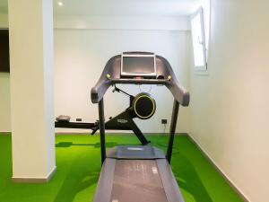 a treadmill in a room with green carpet at In einer klimatisierten Wohnung mit Terrasse in Marone