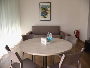 a table with a box of water bottles and chairs at In einer klimatisierten Wohnung mit Terrasse in Marone +23 photos