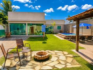 a backyard with a fire pit and chairs and a house at BayShore Lofts in Cabo Frio