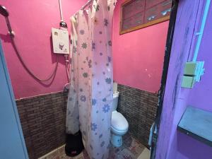 a pink bathroom with a toilet and a shower curtain at Pink Hostel in Ko Tao