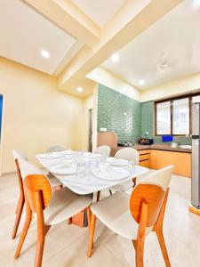 a dining room with a white table and chairs at Sunset havan villa in Lonavala