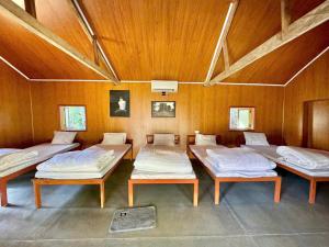 a room with four beds in it with wooden walls at Resort Đồi Thông in Kon Von Kla