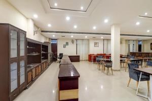 a kitchen and dining room with tables and chairs at Capital O Divira Inn in Dhanbād
