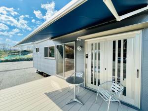 a porch with two chairs and a table on a house at Mobile Home 8 in Hokuto