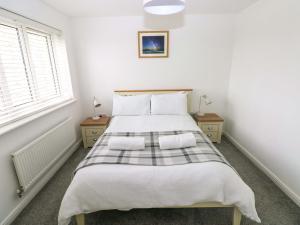 a bedroom with a large bed with two pillows at 69 Ffordd Y Meillion in Llanelli