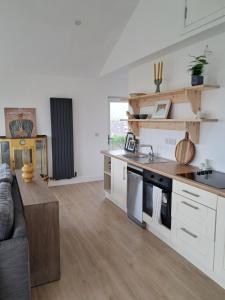 a kitchen with white cabinets and a couch in a room at Tigh Droum in Rosscarbery