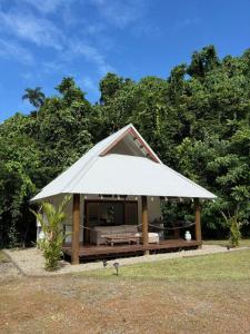 a small house with a large white roof at Coconut Beach House & Cottages in Cape Tribulation