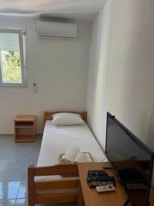 a bedroom with a bed and a desk with a computer at Navora Apartmani in Sutomore