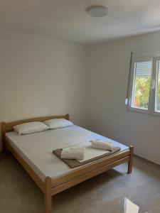 a bed with two pillows on it in a room at Navora Apartmani in Sutomore