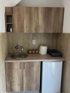 a kitchen counter with a sink and a refrigerator at Navora Apartmani in Sutomore