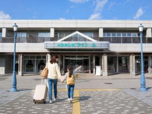 a mother and daughter walking in front of a building at Hotel Lavenir in Biei