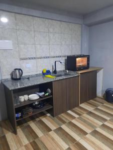 a kitchen with a counter with a sink and a microwave at Linda estadia 2 in San Juan +8 photos
