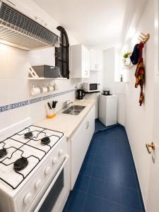 a white kitchen with a stove and a sink at Depto Termas Centro in Termas de Río Hondo