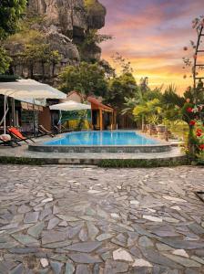 a resort swimming pool with a mountain in the background at Tam Cốc FAIRY WINGS Homestay in Vũ Lâm