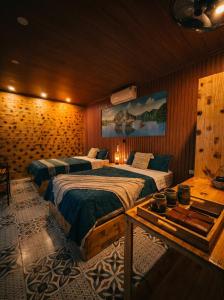 a bedroom with two beds and a table in it at Tam Cốc FAIRY WINGS Homestay in Vũ Lâm