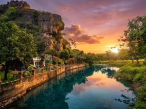 a river in front of a mountain at sunset at Tam Cốc FAIRY WINGS Homestay in Vũ Lâm