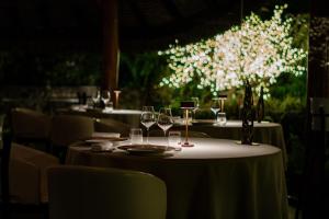 a table with wine glasses and a vase with flowers on it at Le Bora Bora by Pearl Resorts in Bora Bora +56 photos