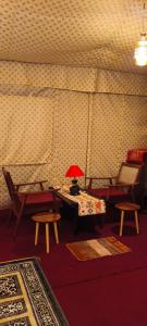 a room with two chairs and a table with a lamp at The Stone Hamlet Retreat in Barkot
