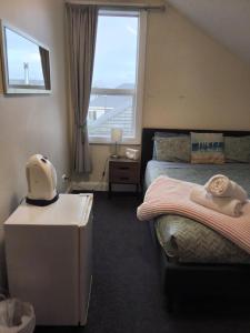a small bedroom with a bed and a window at North Beach Lodge in Christchurch