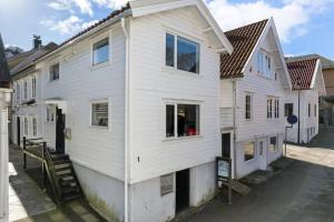 a white house with a lot of windows at Koselig enebolig i Sentrum in Egersund