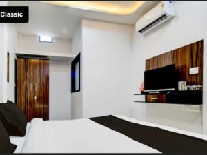 a hotel room with a bed and a tv at Kanakplace in Indore
