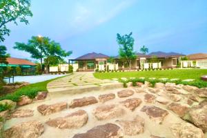 a house with rocks in front of a yard at รักแรกพบรีสอร์ทสัตหีบ in Sattahip