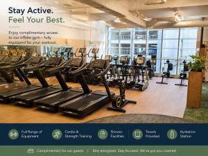 a gym with lots of treadmills and ellipticals at Quest on Queen Serviced Apartments in Auckland