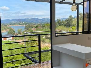 a room with a balcony with a view of a lake at Cabaña XAMAI in La Pradera