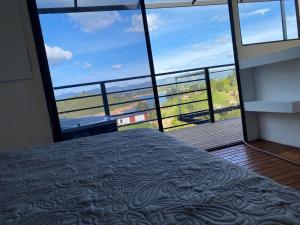 a bedroom with a bed and a view of a balcony at Cabaña XAMAI in La Pradera