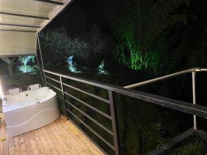 a bathroom with a bath tub next to a forest at night at Cabaña XAMAI in La Pradera