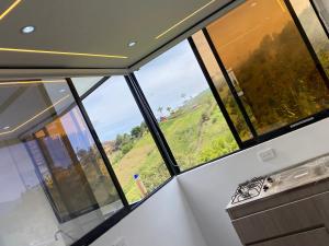 a kitchen with windows and a view of a hill at Cabaña XAMAI in La Pradera