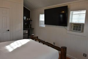 a bedroom with a bed and a flat screen tv at Tiny Yellowstone Riverside Cabin in Gardiner