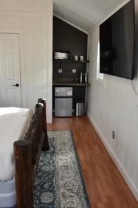 a living room with a tub and a television on the wall at Tiny Yellowstone Riverside Cabin in Gardiner
