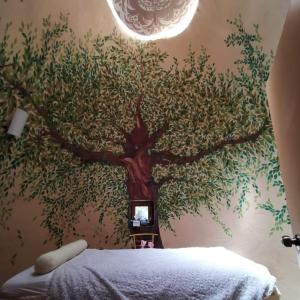 a bedroom with a tree mural on the wall at Luchita Mia Eco Cabañas Boutique in Zacatlán