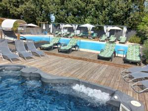 a swimming pool with chairs and a table and a swimming pool at Chalet clim, TV - 2 pers. - API-1-52-2795 in Noves