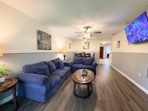 a living room with a blue couch and a table at Disney Kissimmee Condo in Kissimmee